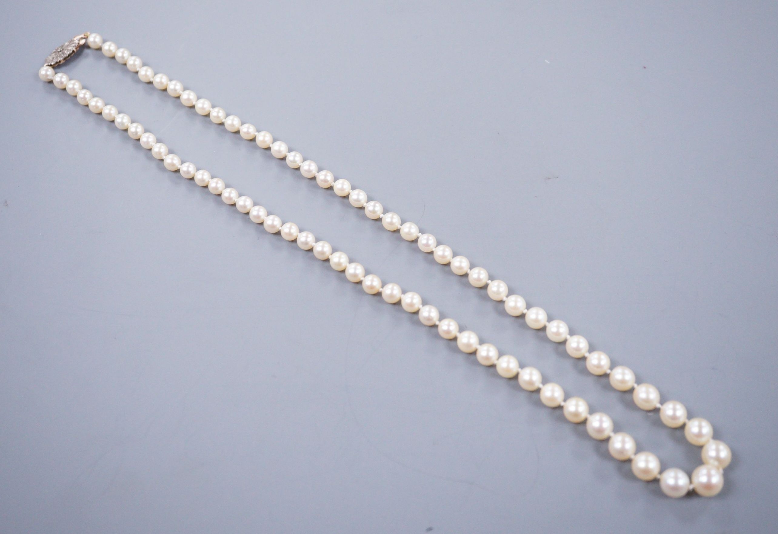 A single strand graduated cultured pearl necklace, with rose cut diamond set yellow metal clasp, 52cm.